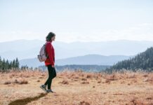 늘어나는 ‘걷기 챌린지’, 일상 속 건강 습관 만들기 열풍 a man with a backpack walking across a dry grass covered field