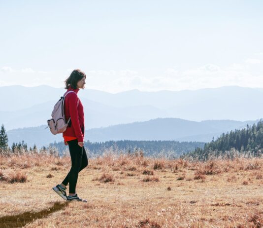 늘어나는 ‘걷기 챌린지’, 일상 속 건강 습관 만들기 열풍 a man with a backpack walking across a dry grass covered field