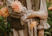 집에서도 실천 가능한 ‘마음 챙김’ 루틴, 스트레스 시대의 건강 관리법 A person in a brown gingham dress and corduroy vest among peach dahlias